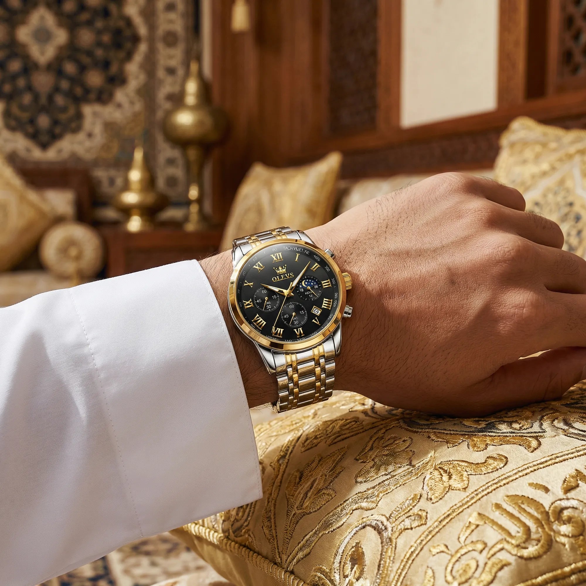 Man wearing a heavy duty gold tone watch on his wrist, showcasing an uncompromising powerful look.