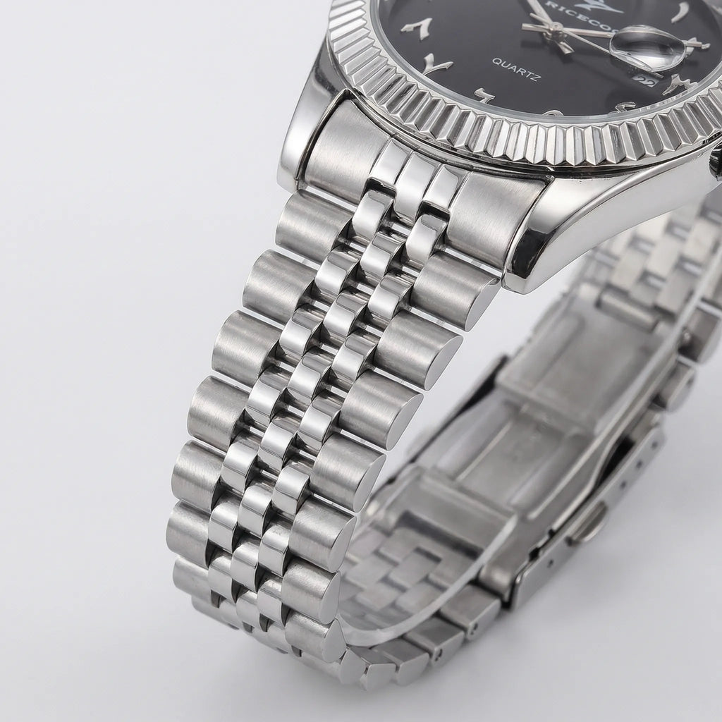 Detailed look at the polished stainless steel bracelet of a silver watch with an Arabic dial.