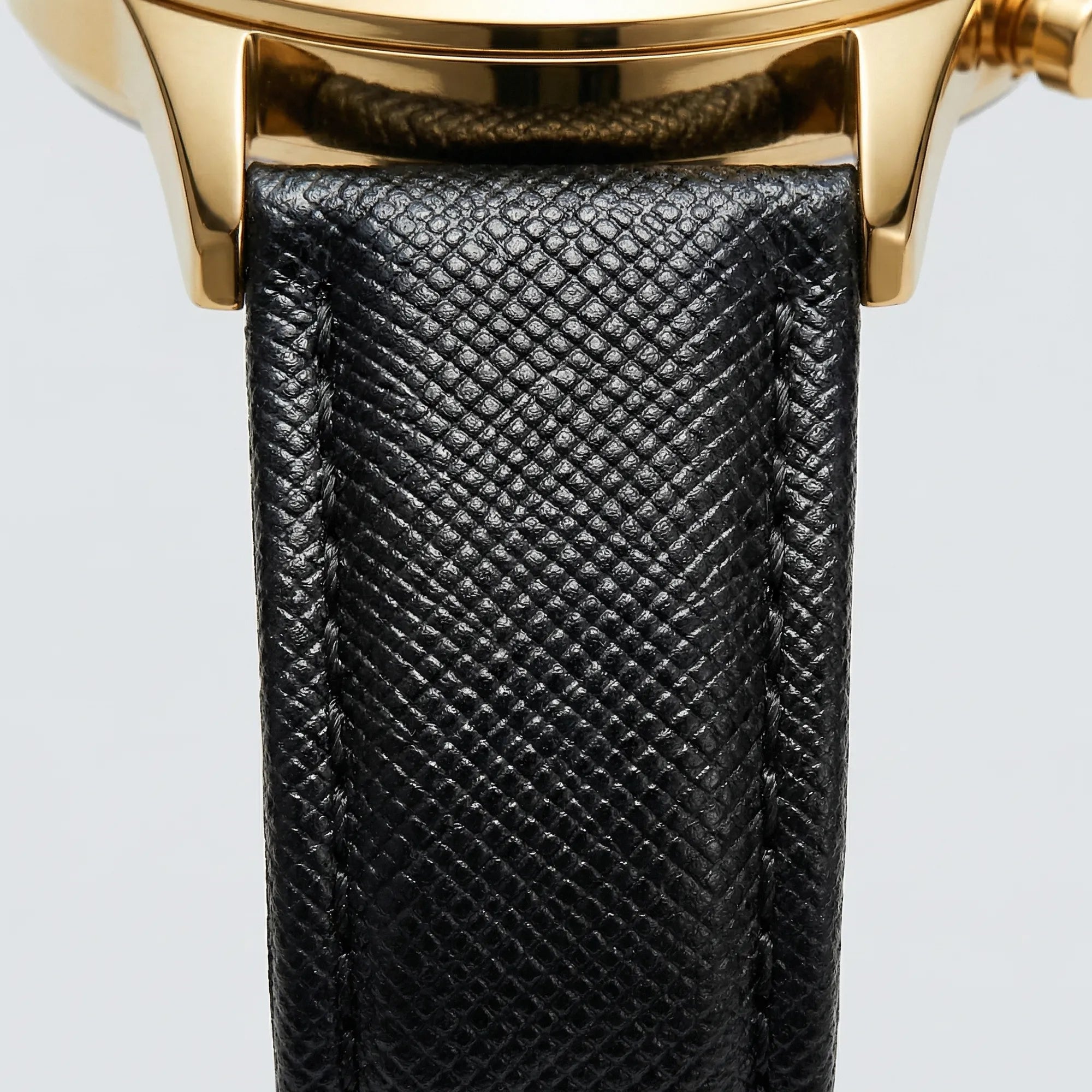 Detailed view of the genuine leather strap on a minimalist gold tone watch, a comfortable dress watch.