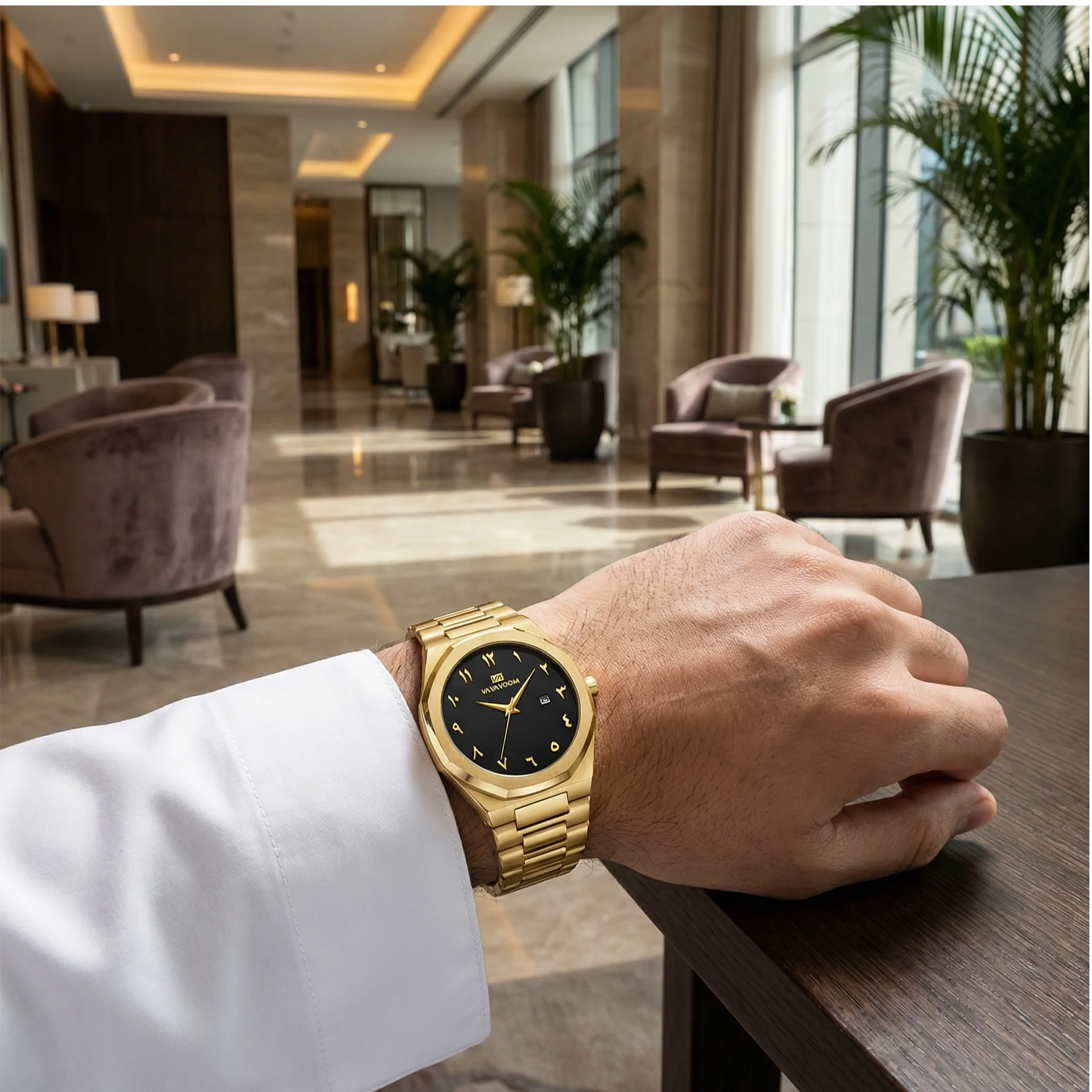 Man wearing an octagonal luxury gold tone watch on his wrist, showcasing architectural brilliance.
