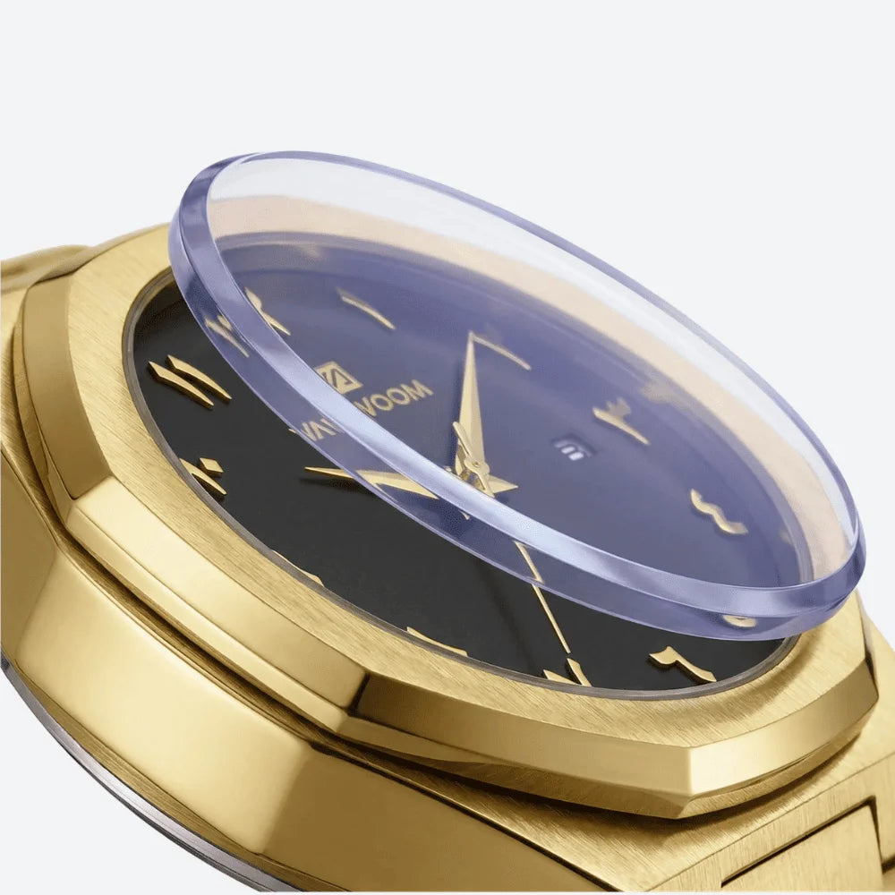 Close-up of the rich gold sunburst dial and Arabic numerals on an octagonal luxury watch.