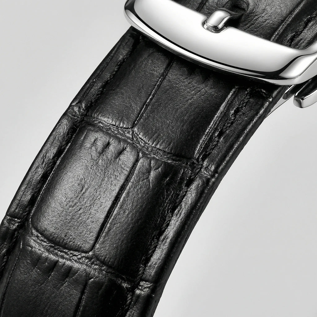 Detailed view of the precision hands on a silver watch with a black dial, a reliable quartz watch.