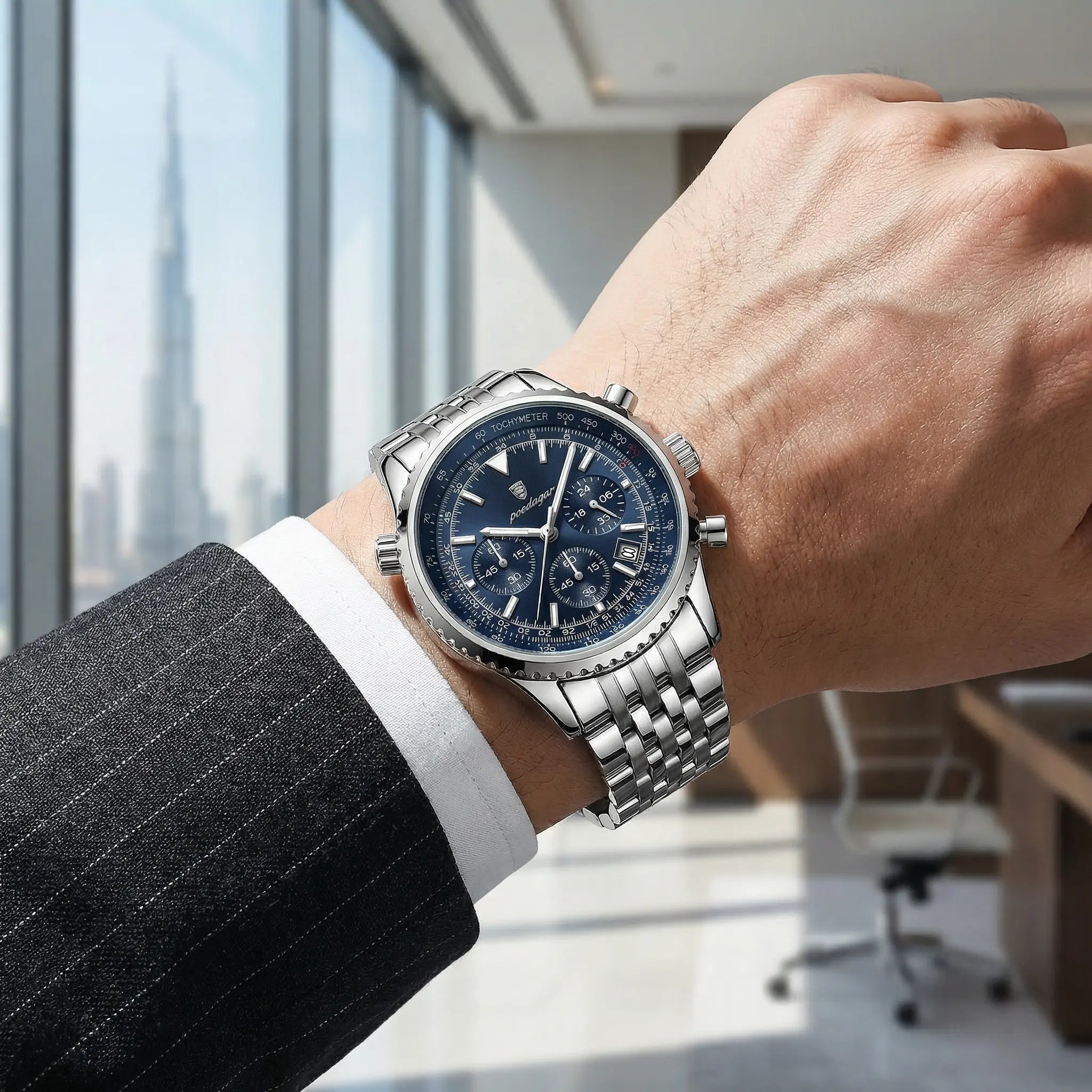 Man wearing a silver stainless steel watch with a blue dial on his wrist, a sophisticated wrist watch.
